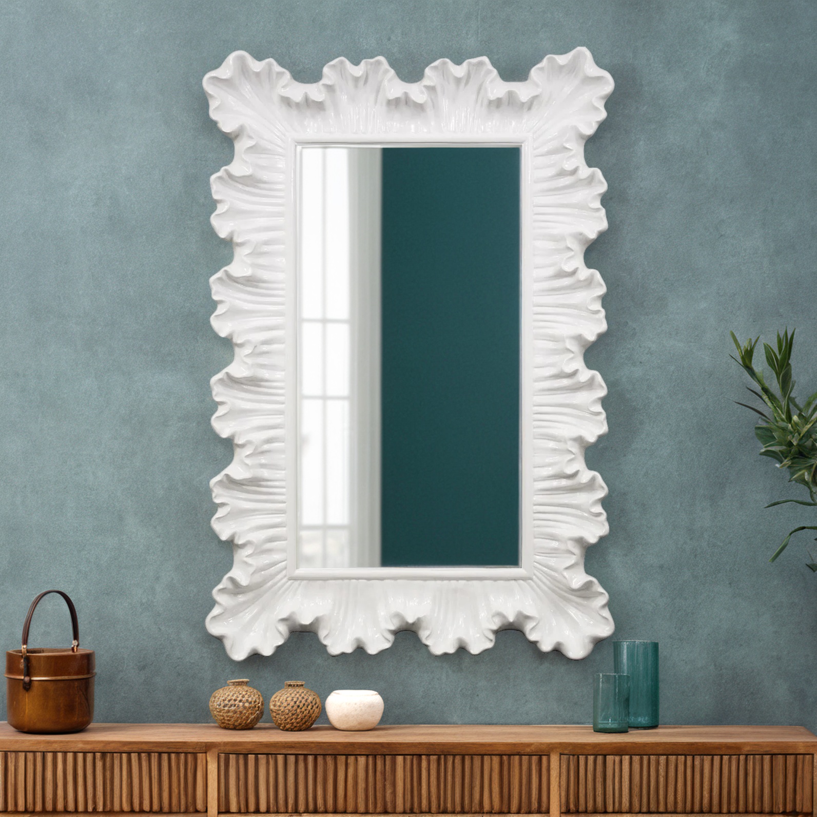 A white mirror mounted on a wall above a console table reflects the living room scene